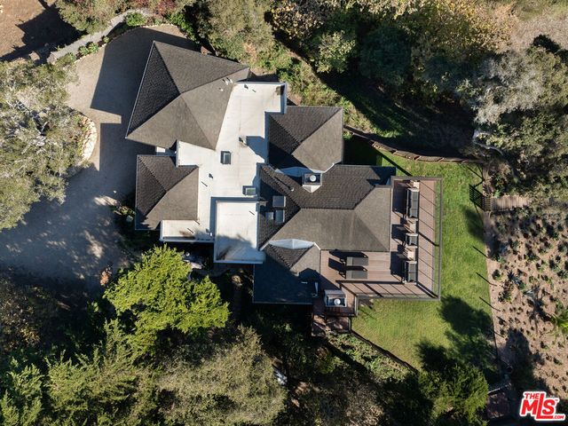 an aerial view of a house with a yard and trees