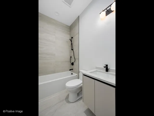 a bathroom with a granite countertop toilet a sink and bathtub