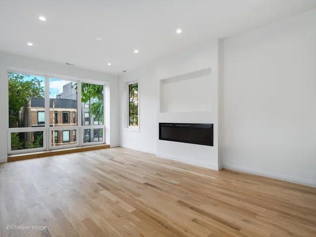 an empty room with wooden floor and a fireplace