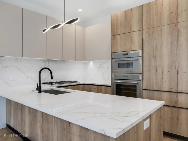 a kitchen with kitchen island a sink appliances and cabinets