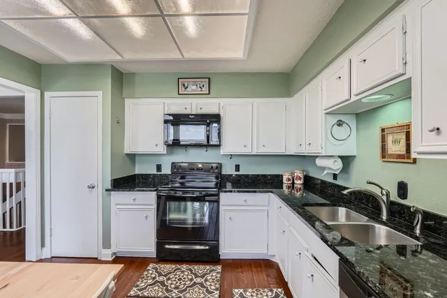 a kitchen with stainless steel appliances granite countertop a sink stove and cabinets