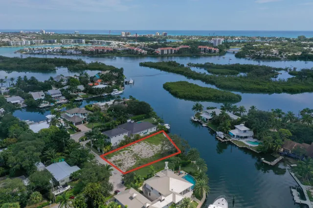 an aerial view of lake residential house with outdoor space and trees all around