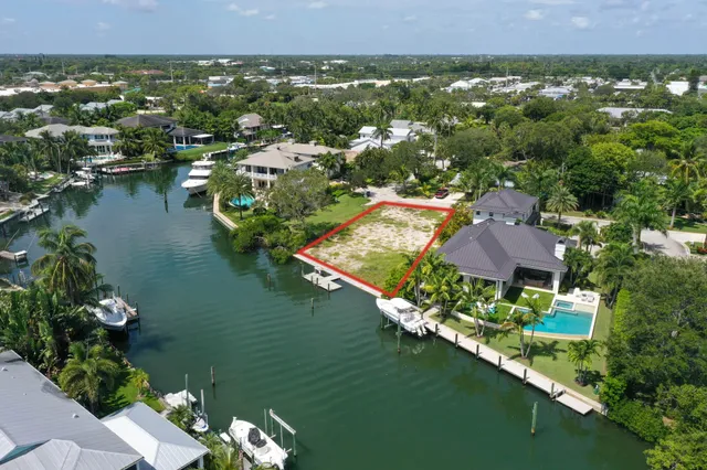 an aerial view of residential houses with outdoor space and lake view