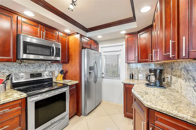 a kitchen with stainless steel appliances granite countertop wooden cabinets a stove top oven a sink and dishwasher