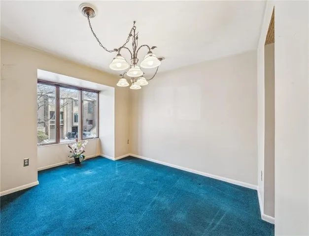 a view of an empty room with wooden floor and windows