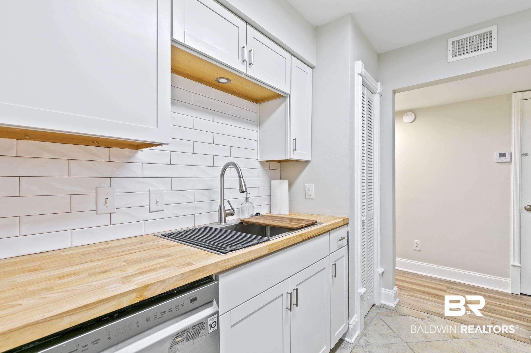 110 5th Street, Unit C103 Daphne, AL 36526 - Photo 23 of 46 Kitchen featuring light wood-type flooring, dishwashing machine, white cabinetry, and sink