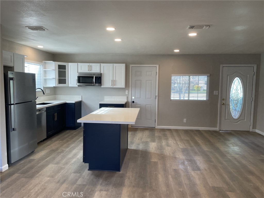 820 North Lassen Street Willows, CA 95988 - Photo 9 of 18 a kitchen with kitchen island a refrigerator wooden floor and a sink