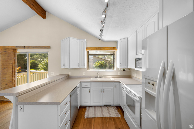2088 Falcon Way Sandy, UT 84093 - Photo 11 of 46 Bright kitchen featuring white cabinetry, light-toned countertops, and integrated appliances