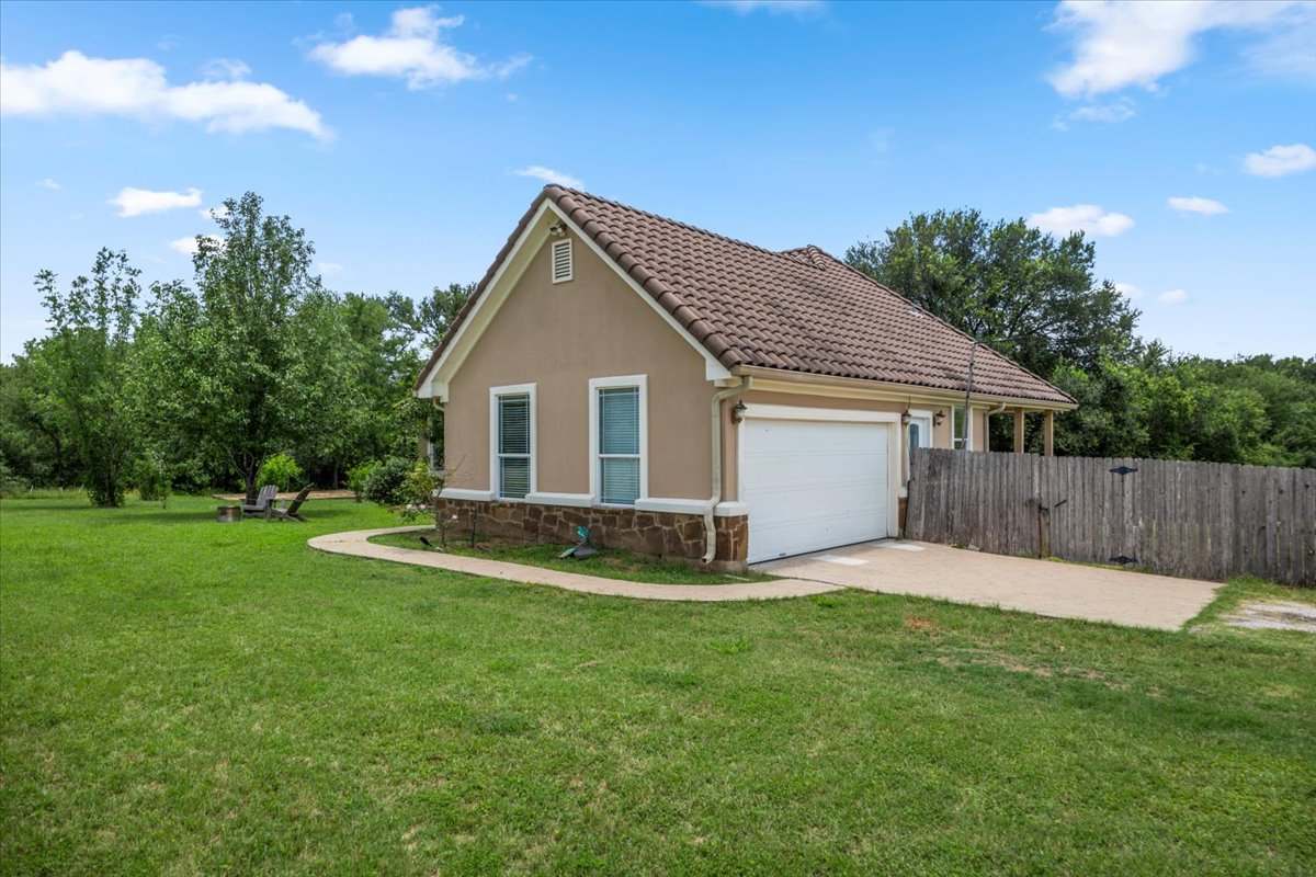 437 Balch Road Elgin, TX 78621 - Photo 28 of 37 A charming stucco home with a tile roof and a private yard for relaxed outdoor living.