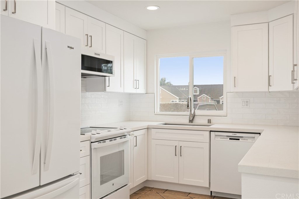 34026 Selva Road, Unit 65 Dana Point, CA 92629 - Photo 8 of 22 a kitchen with white cabinets and white appliances