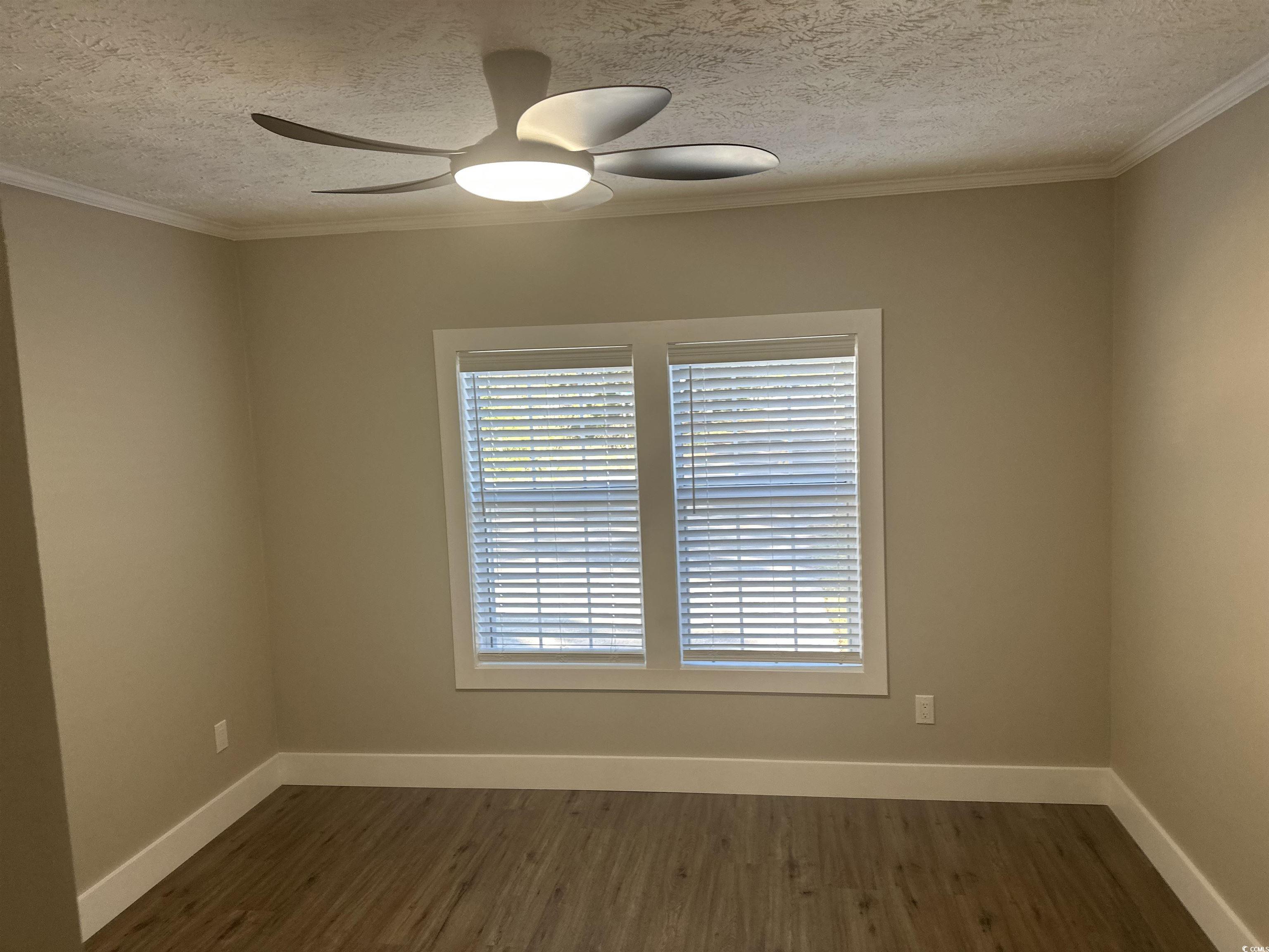 3800 Murrells Inlet Road Murrells Inlet, SC 29576 - Photo 12 of 22 Unfurnished room featuring dark wood-style floors, a textured ceiling, ornamental molding, and a ceiling fan