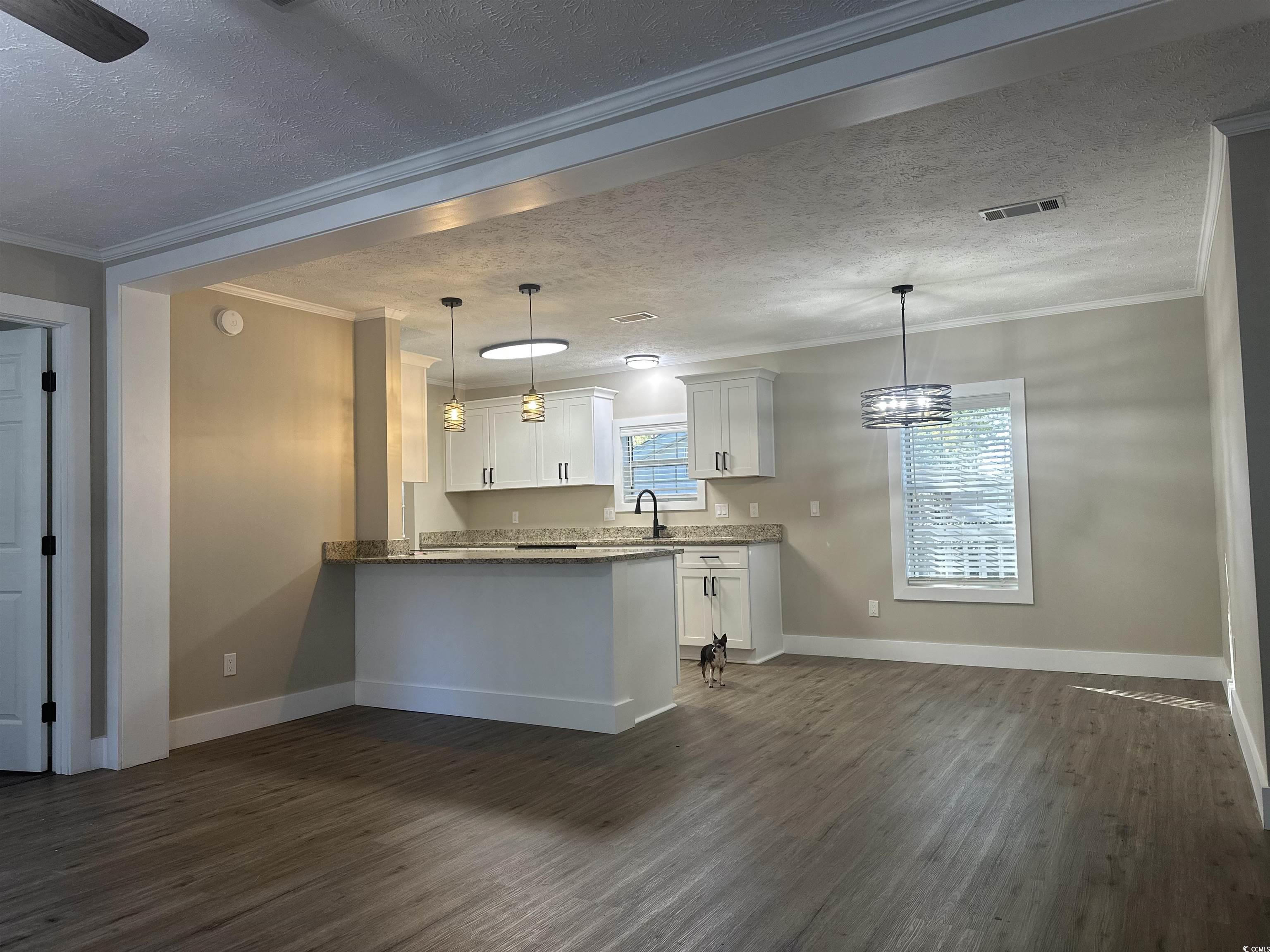 3800 Murrells Inlet Road Murrells Inlet, SC 29576 - Photo 4 of 22 Kitchen with white cabinets, ornamental molding, a textured ceiling, dark wood-style floors, and pendant lighting
