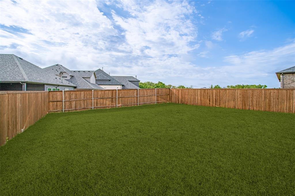 3115 Giovanni Point Princeton, TX 75407 - Photo 25 of 26 Expansive backyard featuring a lush green lawn, full wood privacy fencing, and ample space