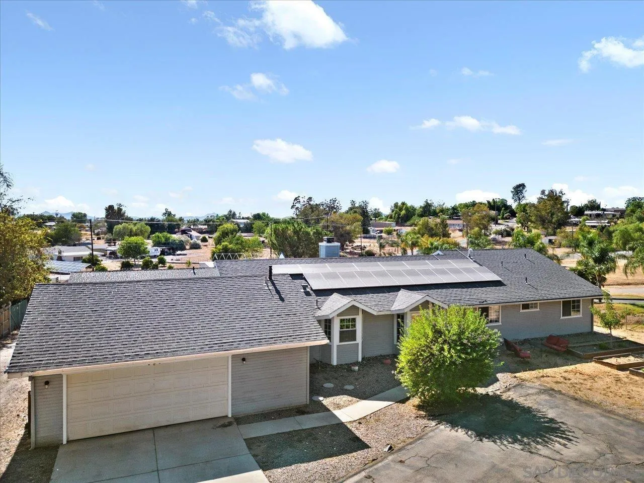 a view of house with a yard and potted plants