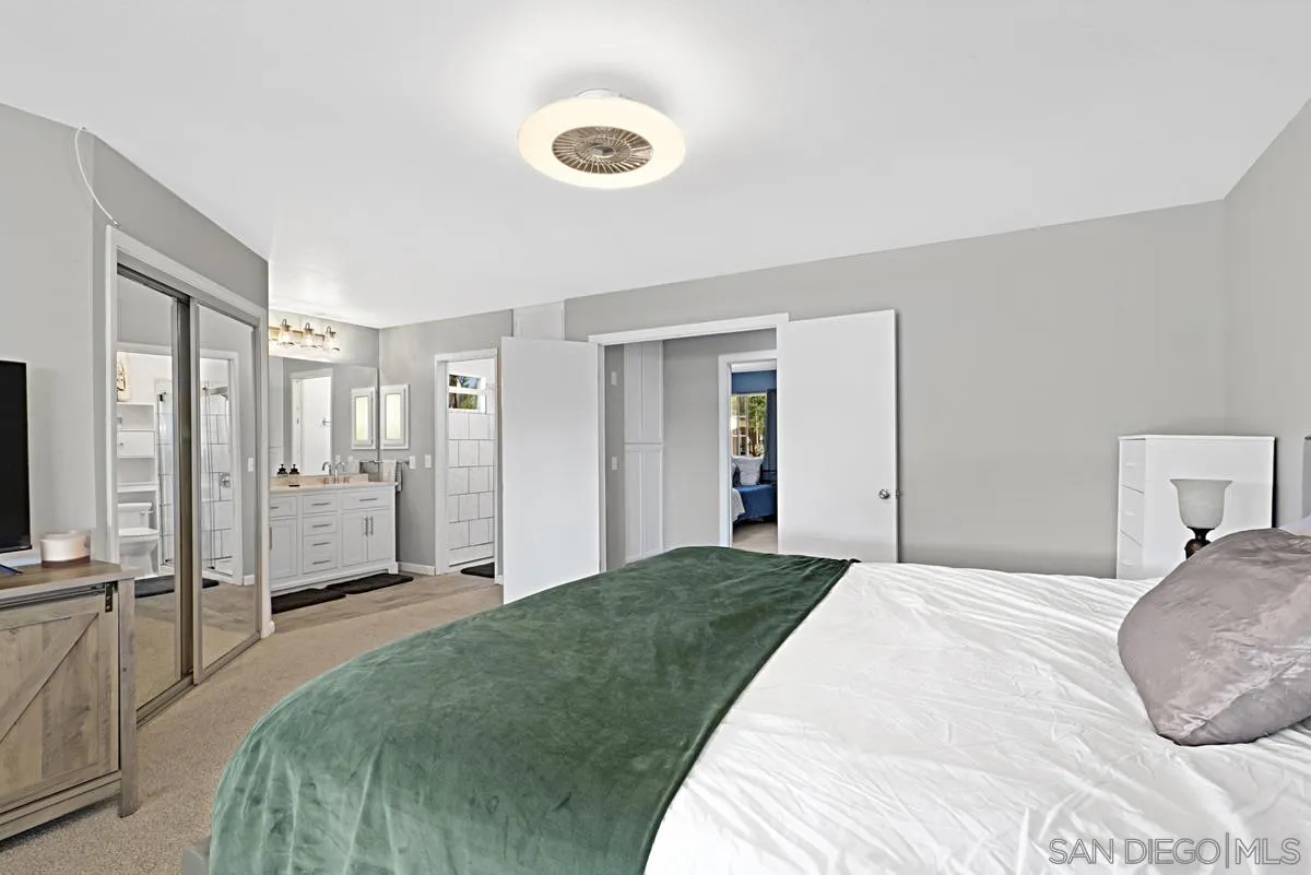 821 Steffy Road Ramona, CA 92065 - Photo 21 of 35 a bedroom with a large bed and a chandelier