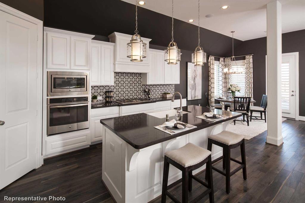 a kitchen with granite countertop a sink appliances and cabinets