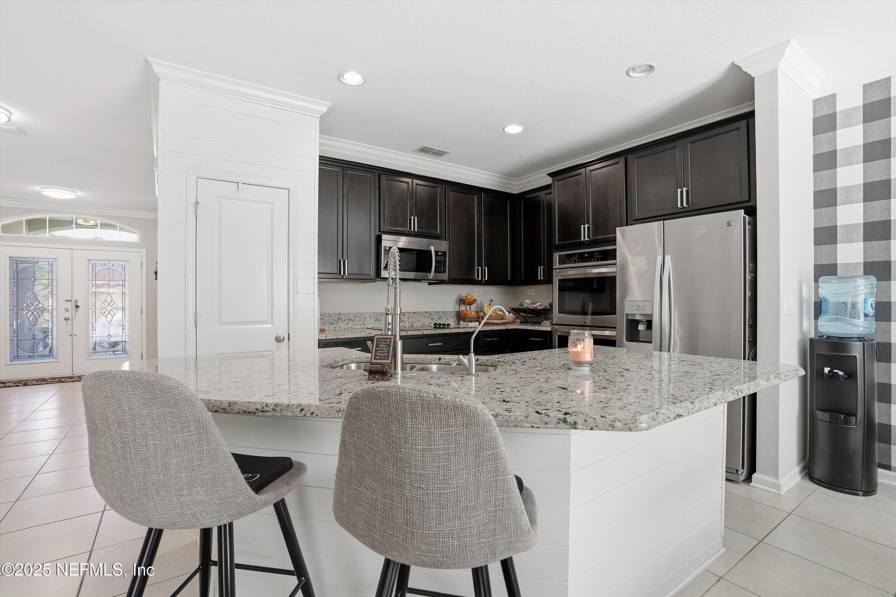 3884 Hammock Bluff Drive Jacksonville, FL 32226 - Photo 12 of 34 a kitchen with stainless steel appliances granite countertop a refrigerator a stove a sink a dining table and chairs