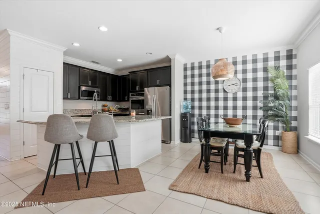 a kitchen with a dining table chairs and white appliances
