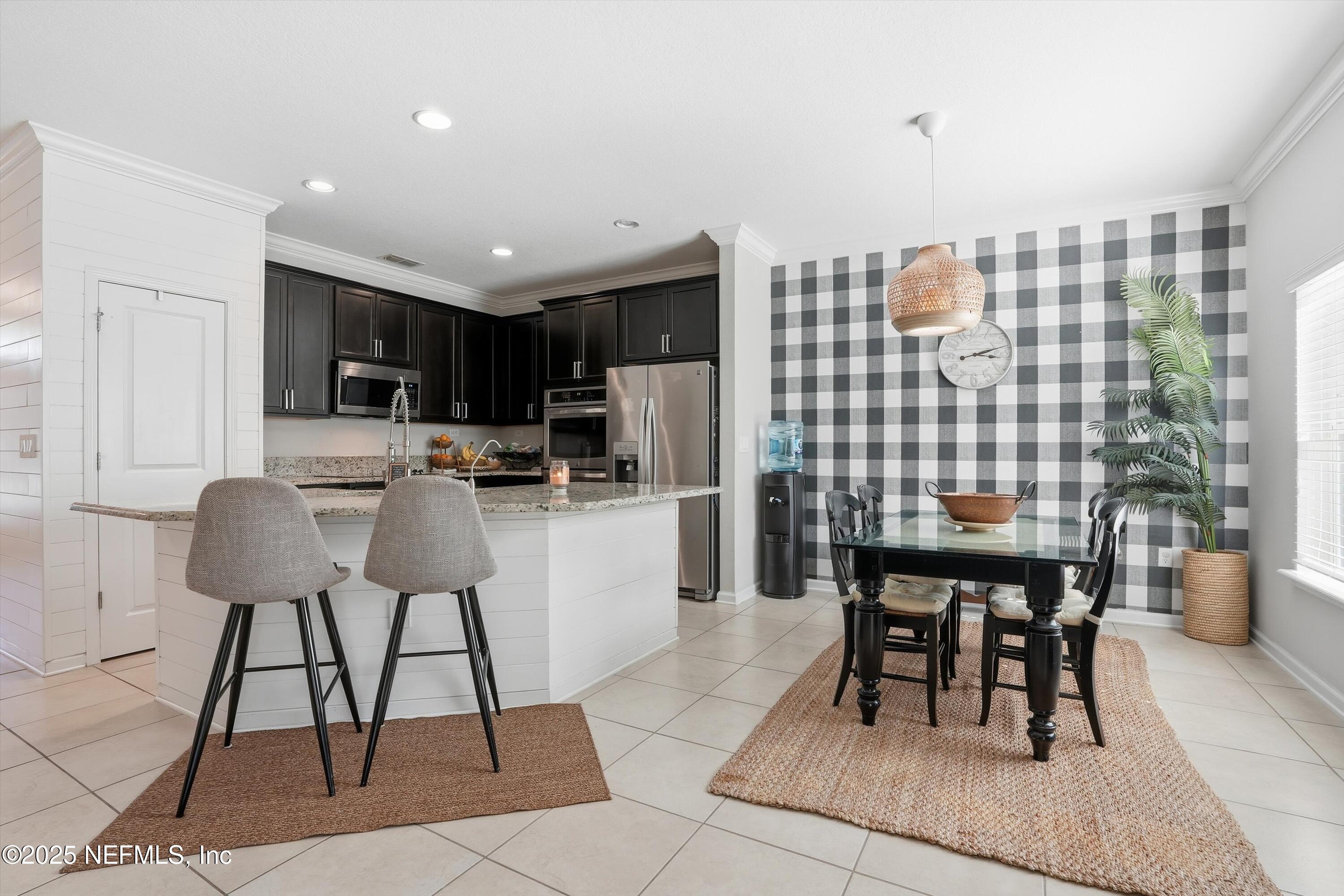 3884 Hammock Bluff Drive Jacksonville, FL 32226 - Photo 14 of 34 a kitchen with a dining table chairs and white appliances