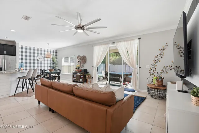 a living room with furniture a flat screen tv and a large window