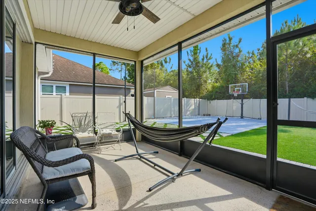 a living room with patio furniture and a floor to ceiling window