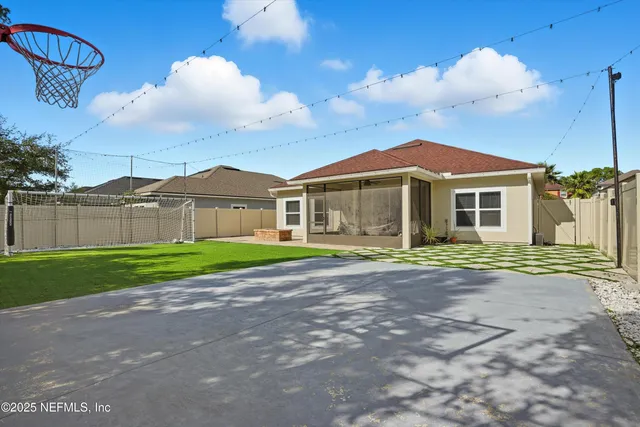 a view of a big house with a big yard and large trees