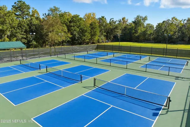 a view of a tennis ground with large trees