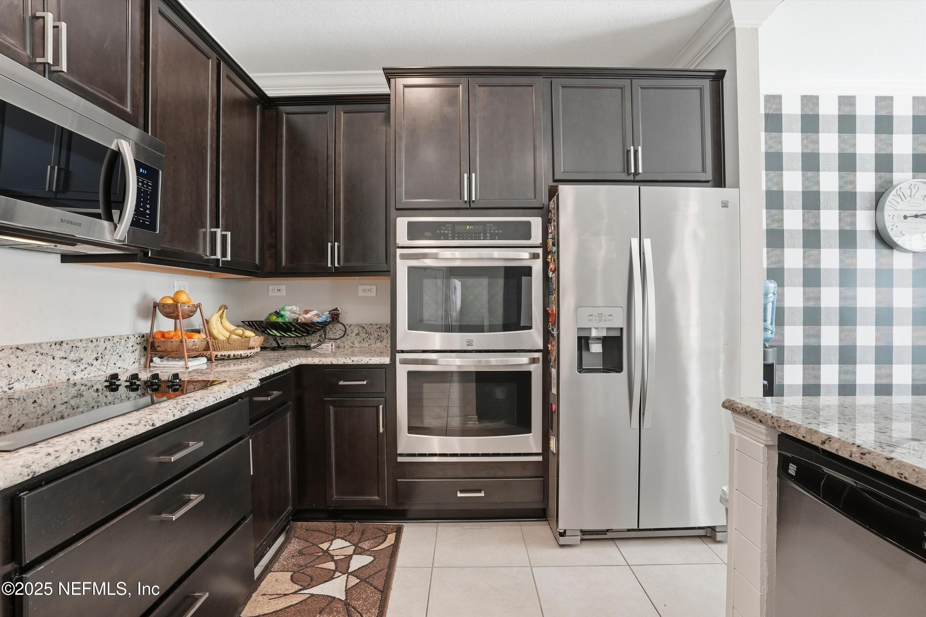 3884 Hammock Bluff Drive Jacksonville, FL 32226 - Photo 3 of 34 a kitchen with granite countertop a refrigerator stove and microwave