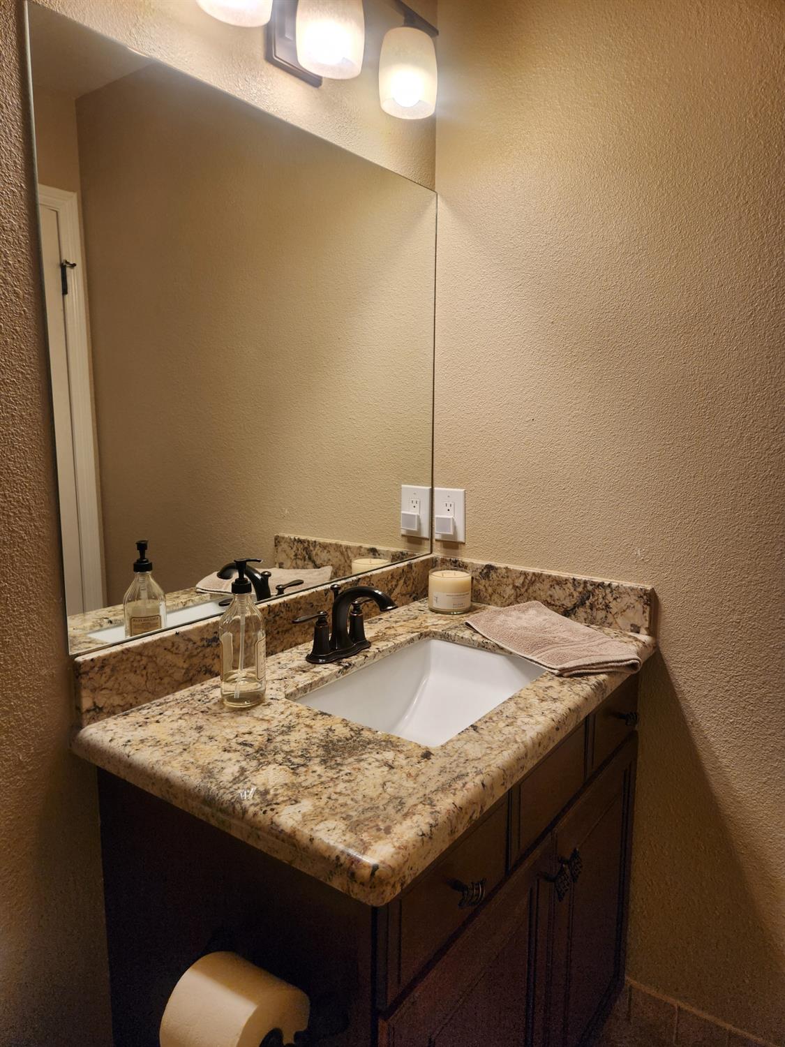 777 Jordanolo Drive Ripon, CA 95366 - Photo 25 of 61 a bathroom with a granite countertop sink and a mirror