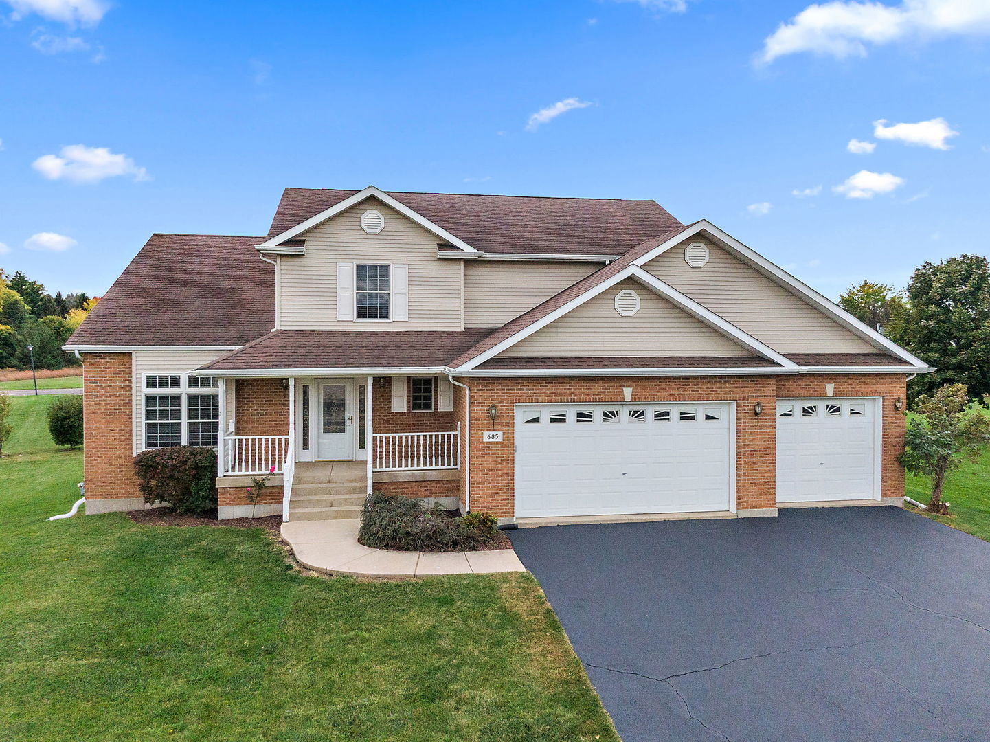 685 Persimmon Street DeKalb, IL 60115 - Photo 2 of 38 a front view of a house with a yard and garage