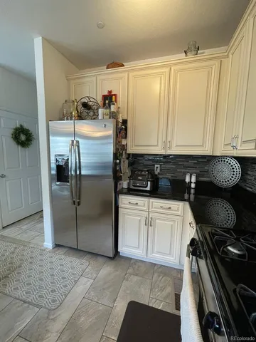 a kitchen with stainless steel appliances granite countertop a sink a stove and a wooden floor