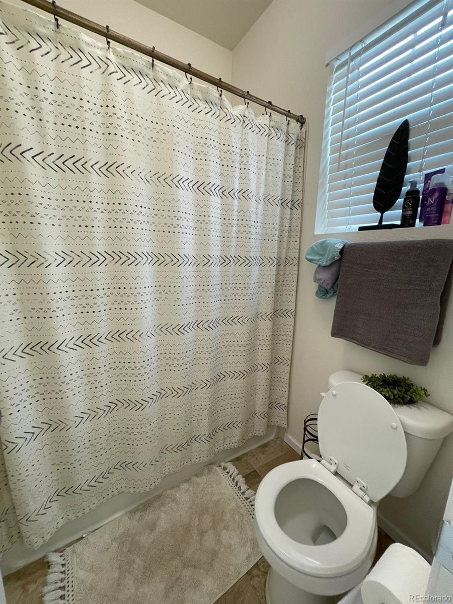 12948 Grant Circle East, Unit B Thornton, CO 80241 - Photo 16 of 24 a white toilet sitting next to a bathroom sink