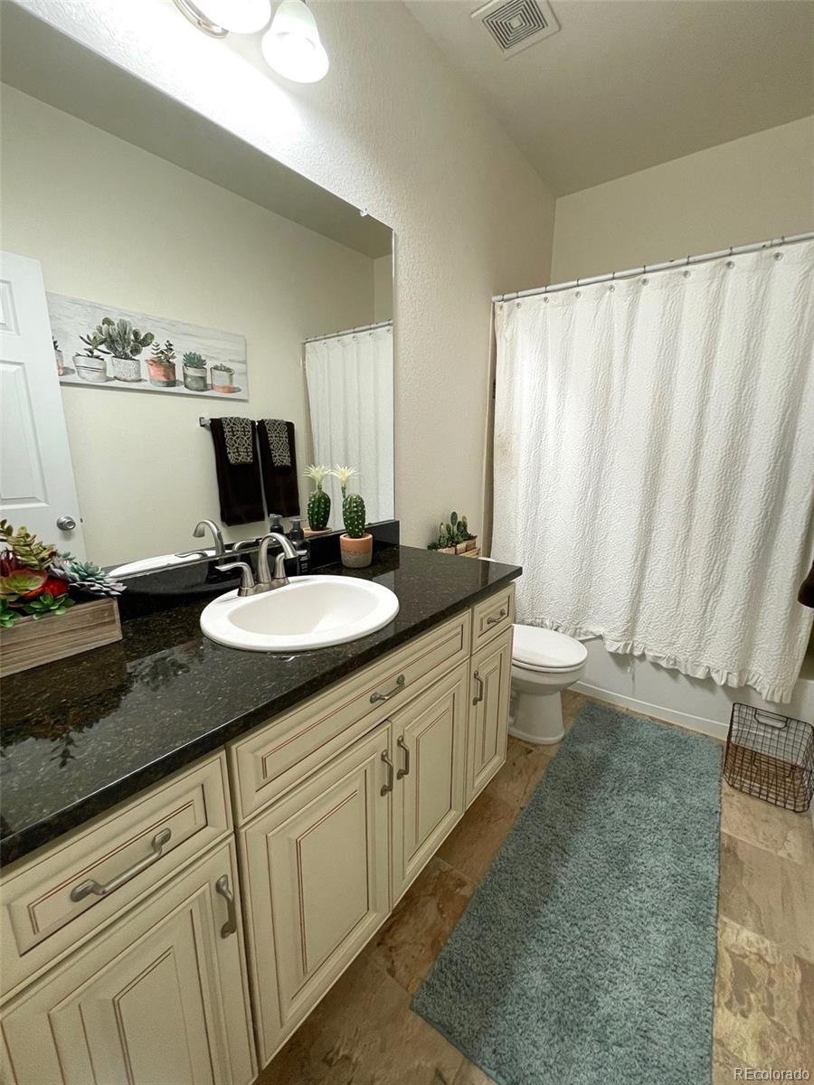 12948 Grant Circle East, Unit B Thornton, CO 80241 - Photo 19 of 24 a bathroom with a granite countertop sink and a mirror