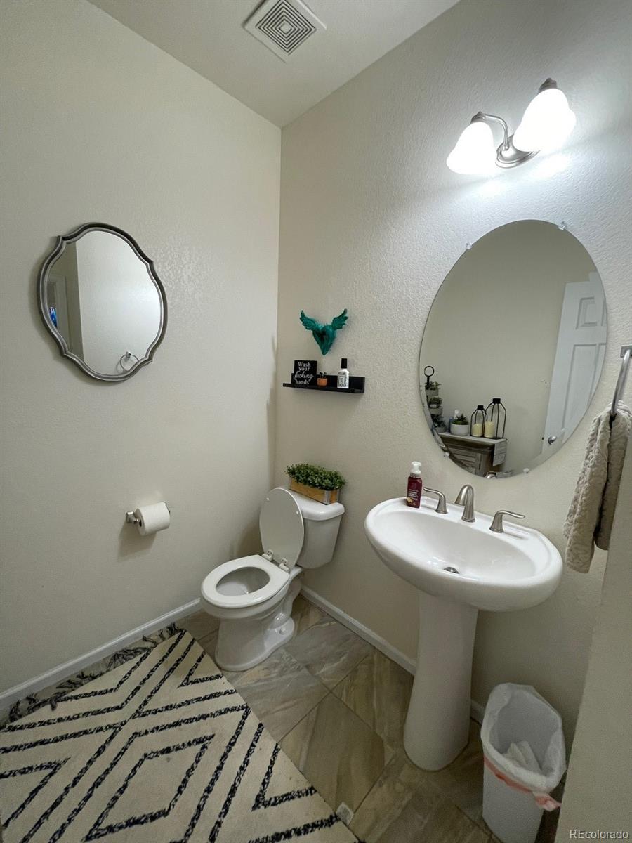 12948 Grant Circle East, Unit B Thornton, CO 80241 - Photo 21 of 24 a bathroom with a toilet sink and mirror