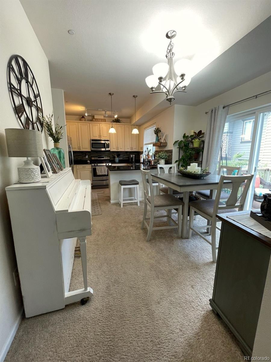 12948 Grant Circle East, Unit B Thornton, CO 80241 - Photo 6 of 24 a living room with furniture a chandelier and a dining table