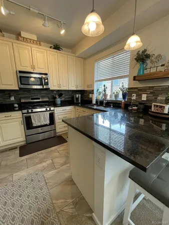 a kitchen with a refrigerator and a stove top oven