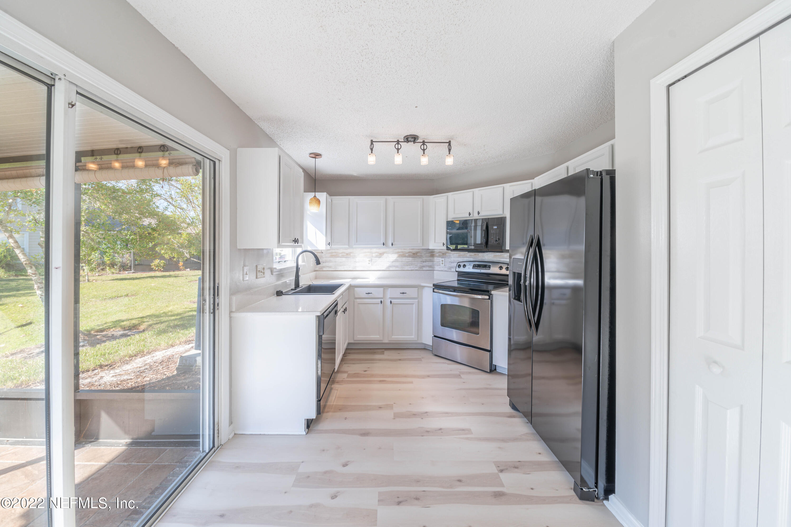 500 South Steel Bridge Road, Unit 3 St. Johns, FL 32259 - Photo 11 of 43 a kitchen with stainless steel appliances granite countertop a refrigerator and a sink