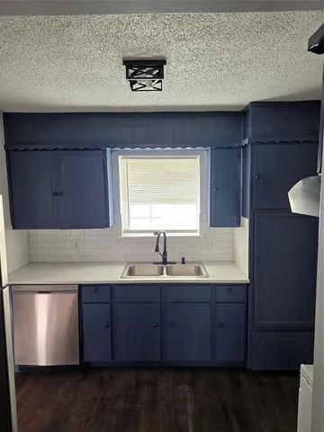 a kitchen with a sink a window and cabinets