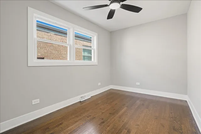 an empty room with a window and a ceiling fan