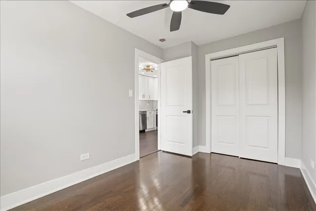 an empty room with a hardwood and ceiling fan