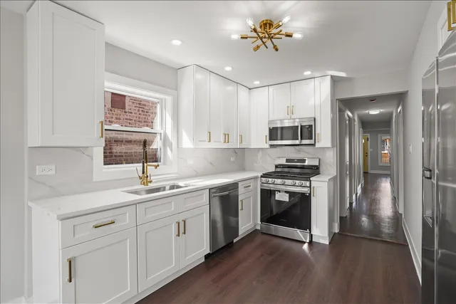 a kitchen with a sink stainless steel appliances and window