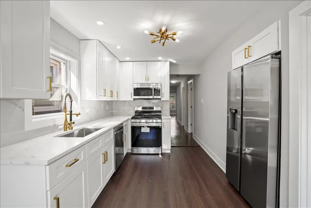a kitchen with stainless steel appliances granite countertop a sink stove and refrigerator