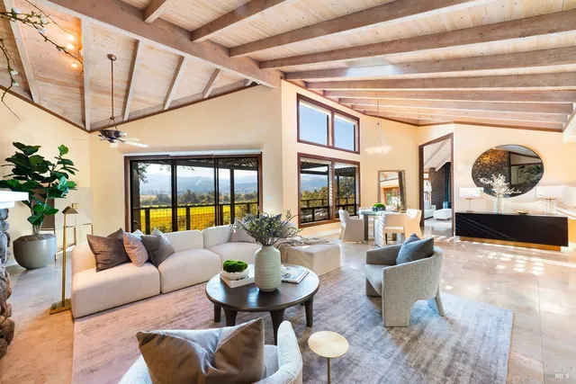 a living room with furniture a chandelier and a large window