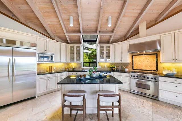 a kitchen with stainless steel appliances granite countertop a stove a sink and a refrigerator