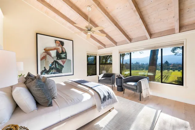 a spacious bedroom with a bed and glass window