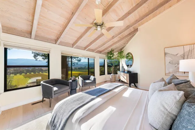 a bedroom with furniture and large windows