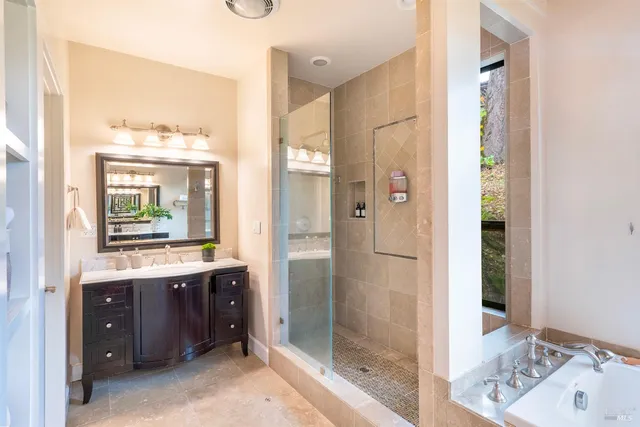 a bathroom with a double vanity sink mirror and shower