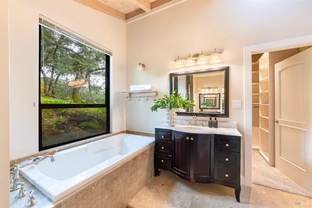 a bathroom with a tub sink and mirror