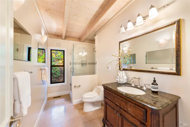 a spacious bathroom with a granite countertop double vanity sink a mirror and a toilet