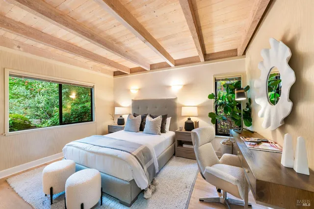 a bedroom with furniture and a large window